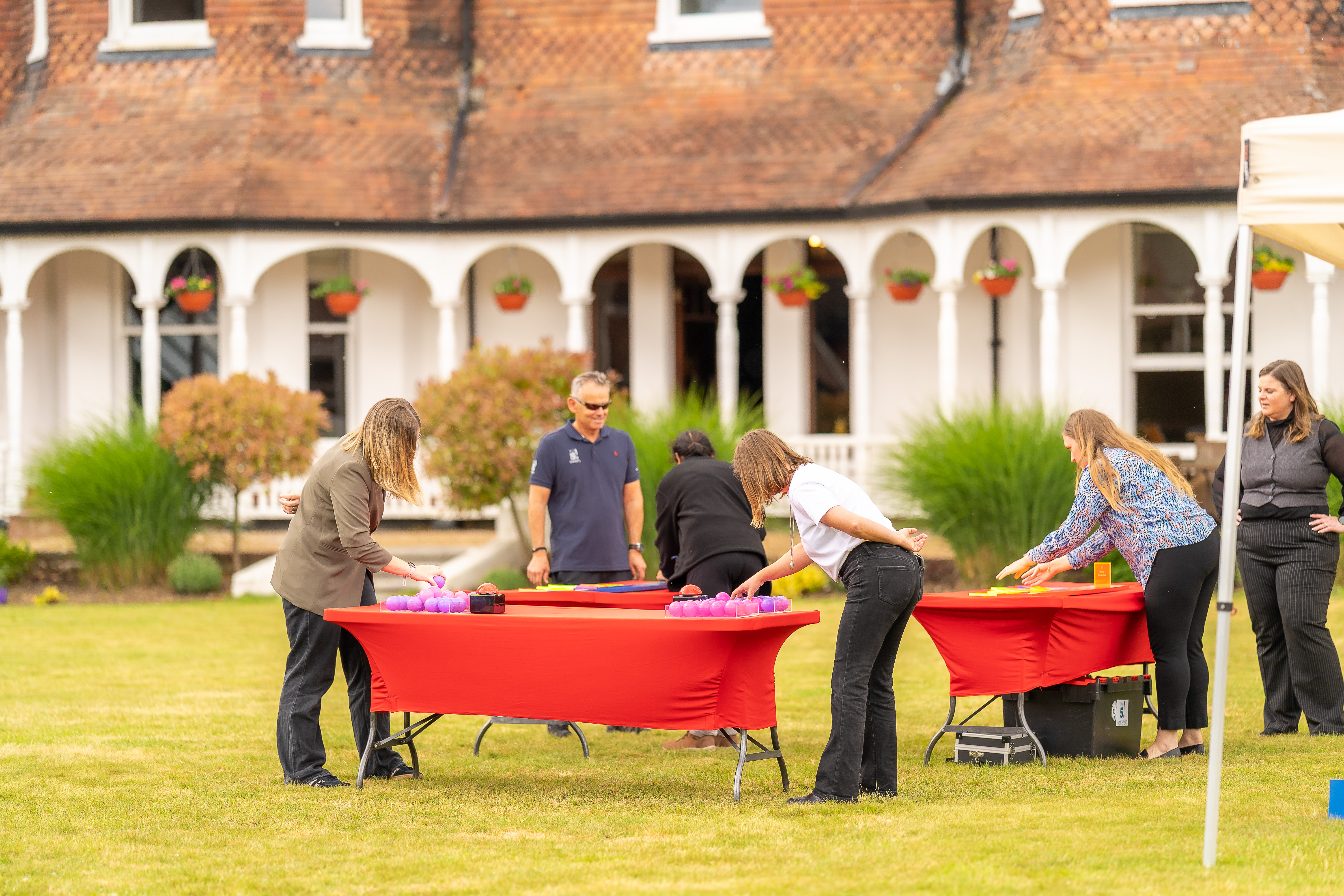 Corporate participants competing in tabletop team activities on the lawns outside CIM Business Centre in Berkshire.